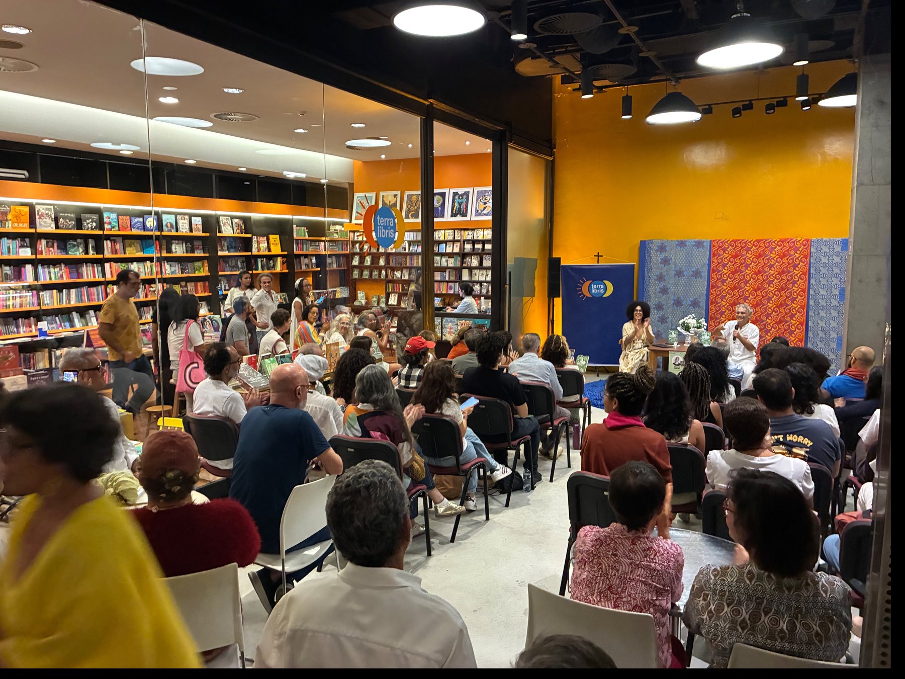 Salão da livraria com mesas e estantes de livros