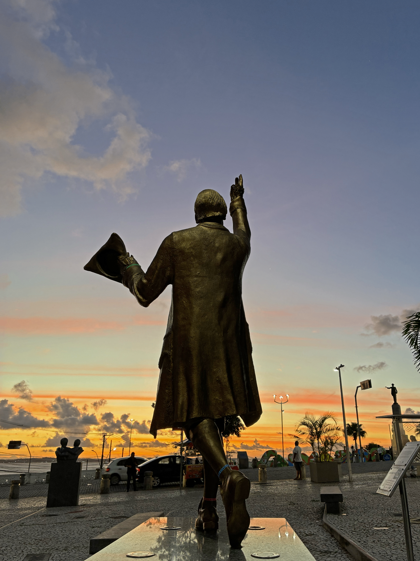 Estátua do poeta Gregório de Mattos Guerra apontando para o monumento a Castro Alves